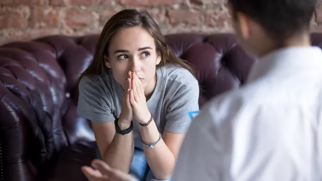 Young person sat in thought whilst talking to support worker