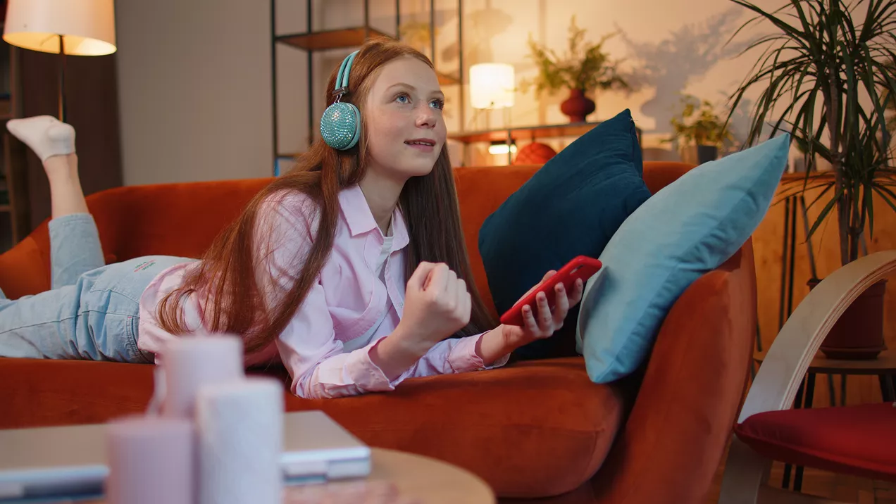 Young Person Using Phone On The Sofa